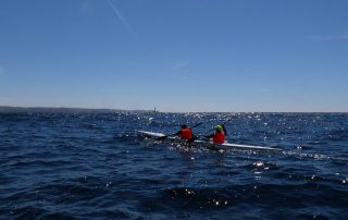 Paddlers in sight of land and the Longships Lighthouse on the Celtic Crossing